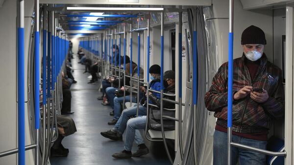 Пассажиры в защитных масках в вагоне Московского метрополитена