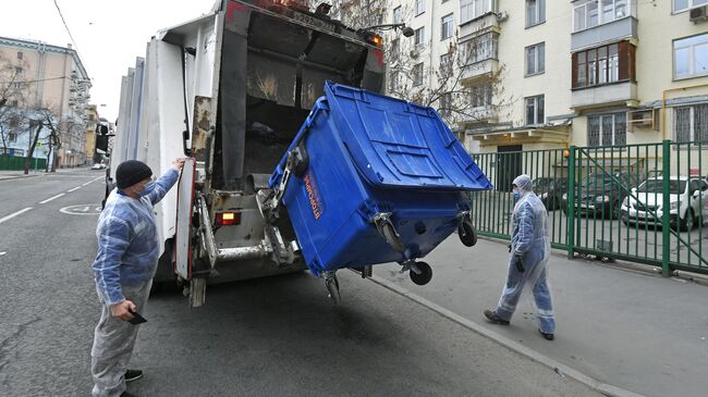 Выгрузка мусора из контейнера в мусоровоз 