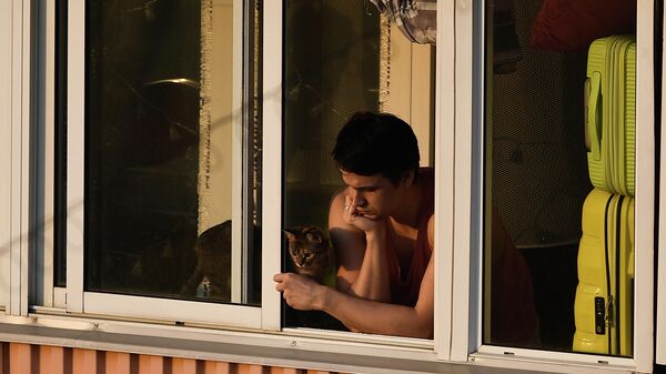 Молодой человек на балконе многоквартирного дома