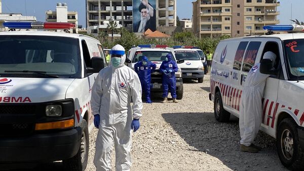 Члены мобилизованных, в рамках программы оказания помощи минздраву Ливана для борьбы с коронавирусом, бригад гражданской обороны Хезболлы у машин скорой помощи в южном Ливане