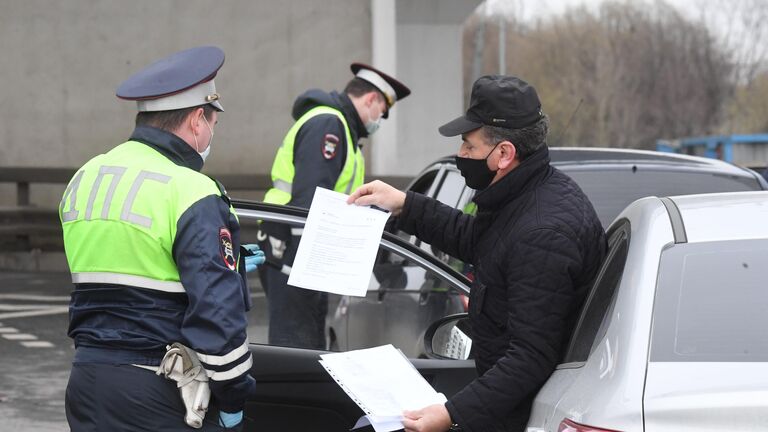 Сотрудники ГИБДД во время проверки электронных пропусков у водителей на блокпосту при въезде в Москву