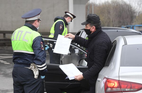 Сотрудники ГИБДД во время проверки электронных пропусков у водителей на блокпосту при въезде в Москву