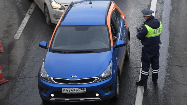 Водитель автомобиля сервиса каршеринга показывает сотруднику ГИБДД на блокпосту при въезде в Москву