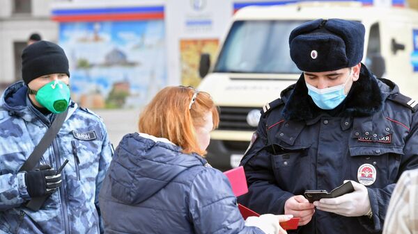 Сотрудник полиции проверяет документы у женщины в Москве