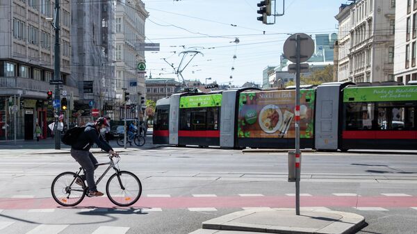 Мужчина в маске едет на велосипеде в Вене