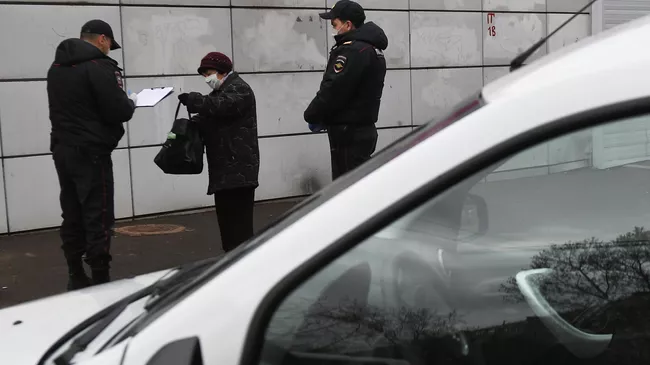 Сотрудники полиции разговаривают с прохожей