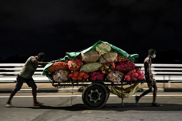 Рабочие с тележкой овощей на пустынной улице в Коломбо