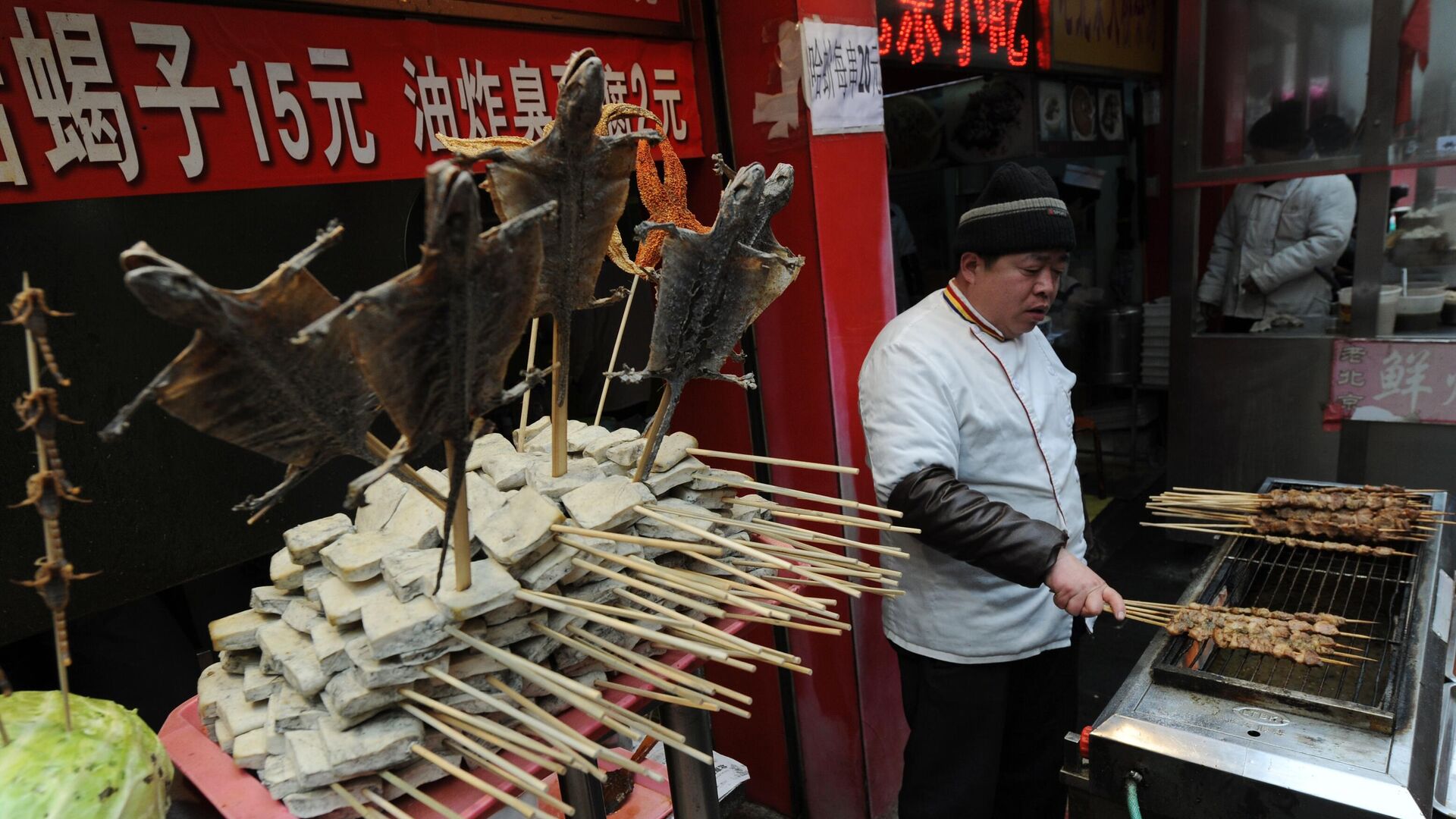 Продавец в киоске экзотической еды на торговой улице Ванфуцзин в Пекине - РИА Новости, 1920, 18.04.2020