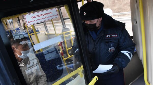 Инспектор дорожно-патрульной службы проверяет документы у пассажира автобуса