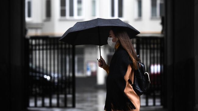 Девушка под зонтом на одной из улиц Москвы