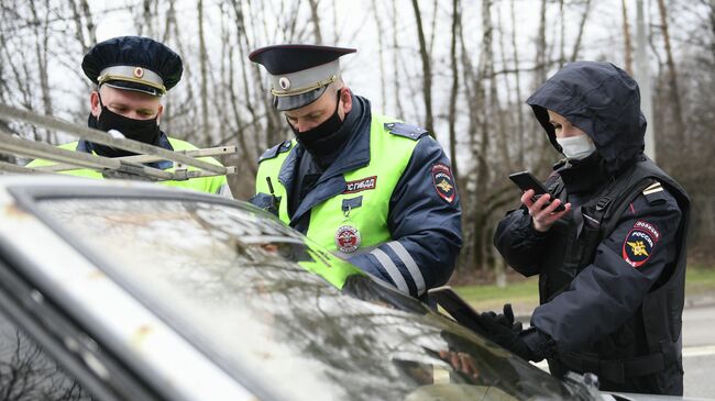 Инспекторы дорожно-патрульной службы проверяют у водителя цифровой пропуск