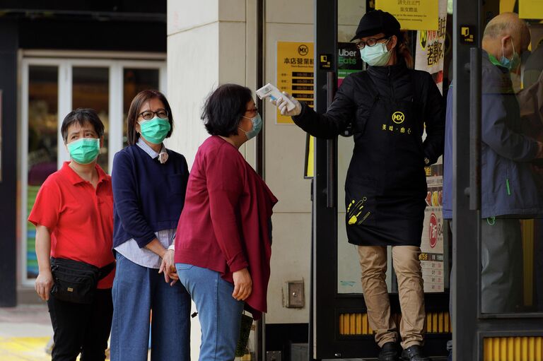 Измерение температуры тела у посетителей ресторана в Гонконге Измерение температуры тела у посетителей ресторана в Гонконге
