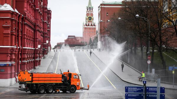 Автомобиль коммунальных служб дезинфицирует дороги и тротуары у Красной площади в Москве