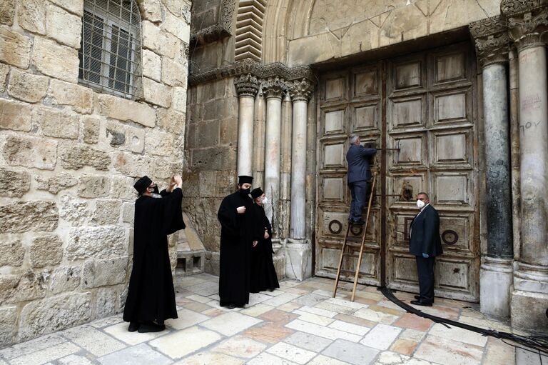 Православные священнослужители и церковные чиновники отпирают Храма Гроба Господня в Иерусалиме в  Страстную пятницу