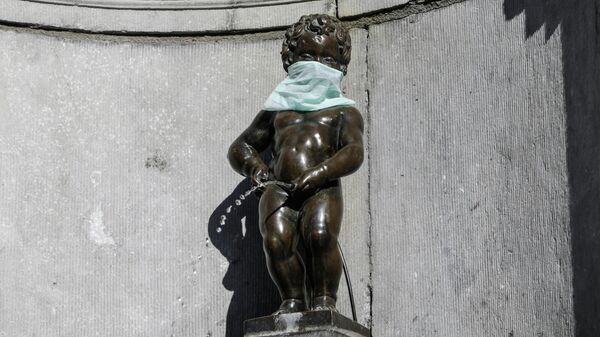 Статуя Писающий мальчик в защитной маске во время вспышки коронавирусной инфекции (COVID-19) в Брюсселе