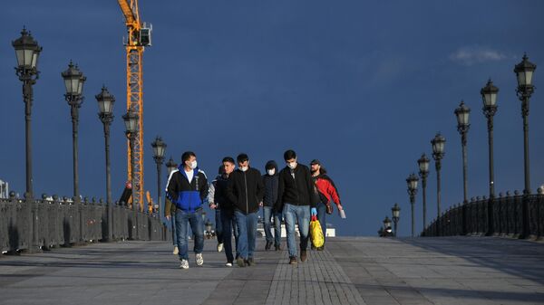 Пешеходы идут по Патриаршему мосту в Москве