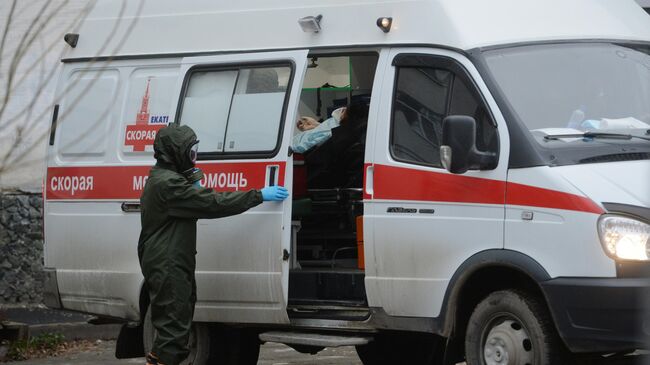 Медицинский работник в защитном костюме у здания Центральной городской клинической больницы No 1 в Екатеринбурге