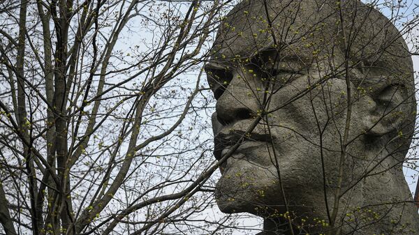Распускающиеся почки на дереве на фоне памятника В. И. Ленину
