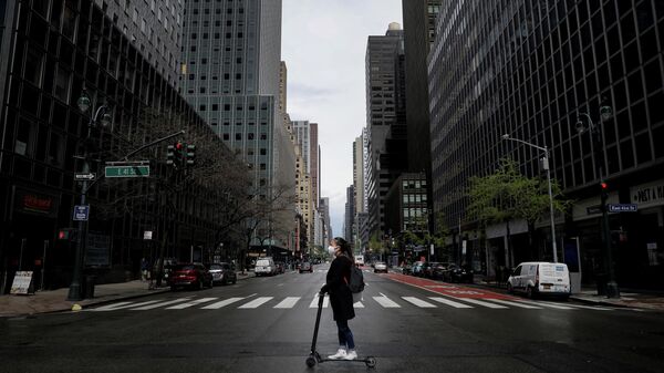 Девушка в защитной маске едет на самокате по улице в Нью-Йорке