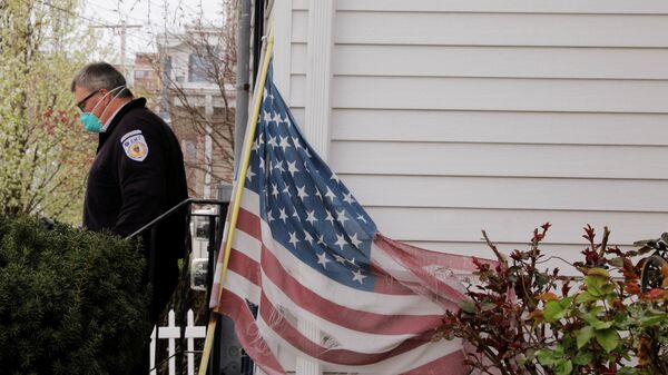 Медик в защитной маске выходит из дома в Эверетте, штат Массачусетс