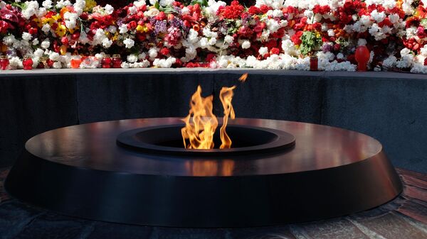 Цветы у Вечного огня Мемориального комплекса Цицернакаберд в Ереване в память о жертвах геноцида армян в Османской империи 1915 года