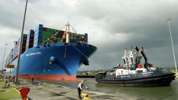 Работник Панамского канала стыкует китайский контейнеровоз Cosco