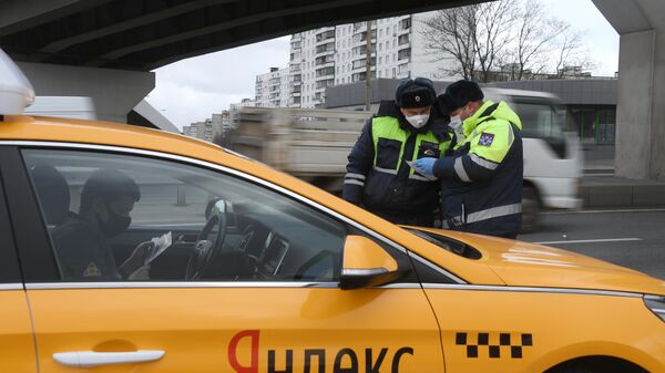 Инспекторы дорожно-патрульной службы во время проверки наличия цифрового пропуска на передвижение по Москве