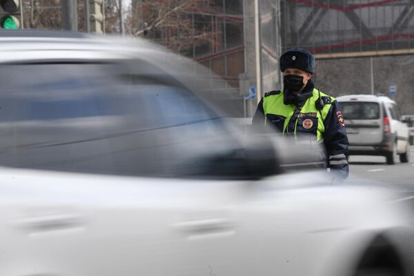 Инспектор дорожно-патрульной службы во время проверки наличия цифрового пропуска на передвижение по Москве