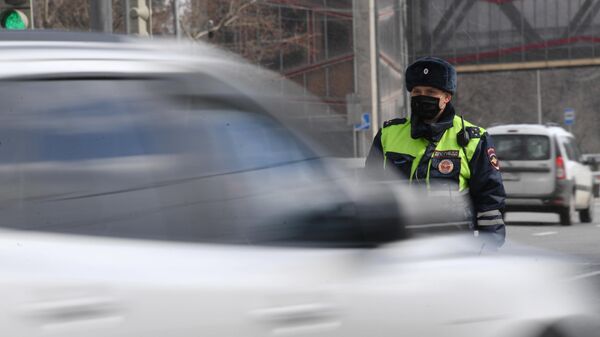 Инспектор дорожно-патрульной службы во время проверки наличия цифрового пропуска на передвижение по Москве