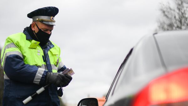 Инспектор дорожно-патрульной службы проверяет документы у водителя