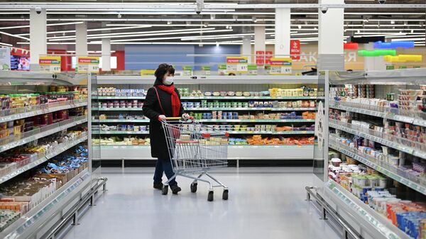 Женщина в защитной маске в гипермаркете