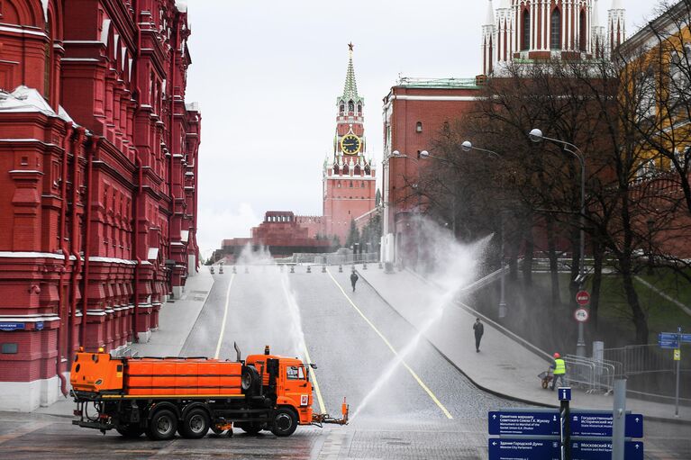 Автомобиль коммунальных служб дезинфицирует дороги и тротуары у Красной площади в Москве