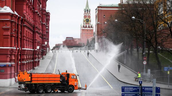 Автомобиль коммунальных служб дезинфицирует дороги и тротуары у Красной площади в Москве