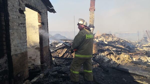 Сотрудники МЧС во время ликвидации пожара в деревне Постниково Ижморского района Кемеровской области