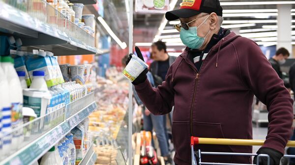 Мужчина в защитной маске покупает продукты в гипермаркете 