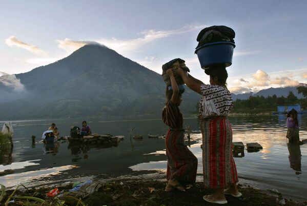 Женщины стирают одежду в озере Атитлан у подножия вулкана Сан-Педро, Гватемала