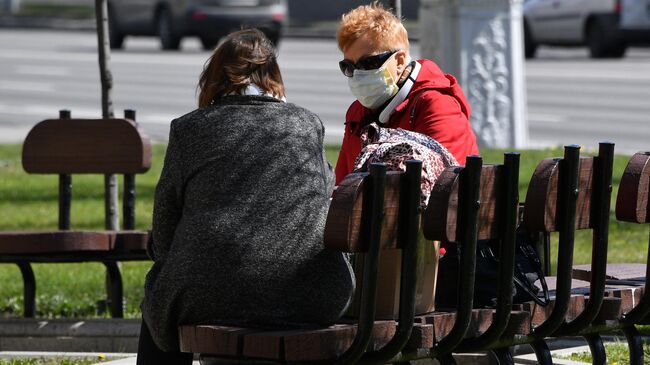 Женщины в защитных масках отдыхают в сквере на проспекте Независимости в Минске