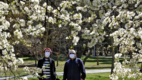 Мужчина и женщина в защитных масках в парке Челюскинцев в Минске