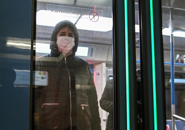 Женщина в защитной маске в вагоне поезда на станции метро Новокузнецкая в Москве