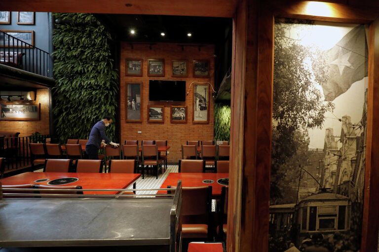 Мужчина производит дезинфекцию в ресторане Ханоя, Вьетнам Мужчина производит дезинфекцию в ресторане Ханоя, Вьетнам