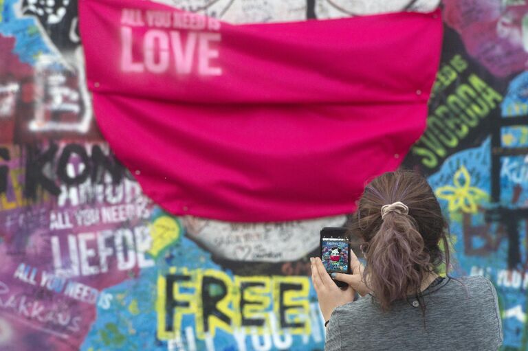 Девушка у стены Джона Леннона в Праге Девушка у стены Джона Леннона в Праге