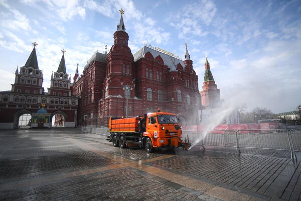 Автомобиль коммунальных служб дезинфицирует дороги и тротуары в центре Москвы.