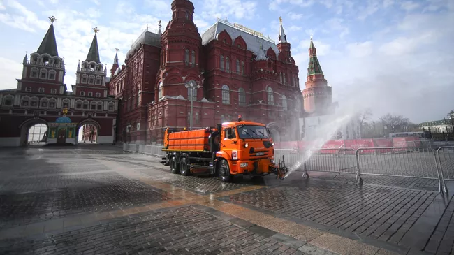 Автомобиль коммунальных служб дезинфицирует дороги и тротуары в центре Москвы.