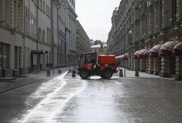 Автомобиль коммунальных служб дезинфицирует дороги и тротуары в центре Москвы