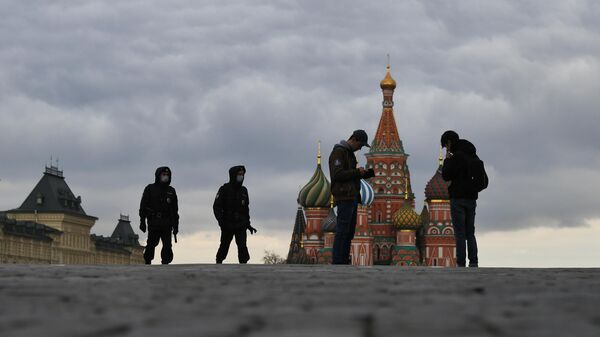 Сотрудники полиции подходят к прохожим на Красной площади в Москве в дни действия режима повышенной готовности из-за коронавируса 