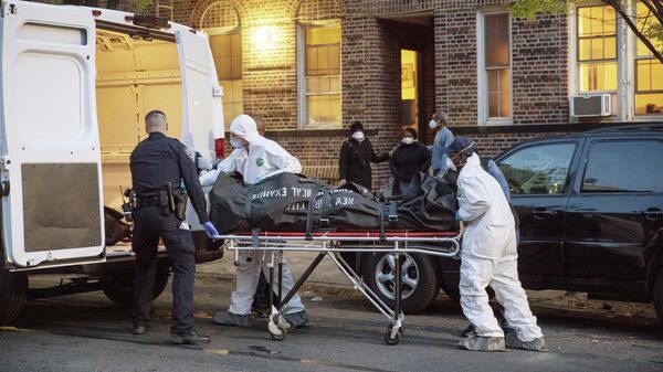 Сотрудник полицейского управления Нью-Йорка помогает рабочим вынести тело из дома в  Бруклине, Нью-Йорк