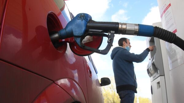 Мужчина оплачивает автомобильное топливо на АЗС