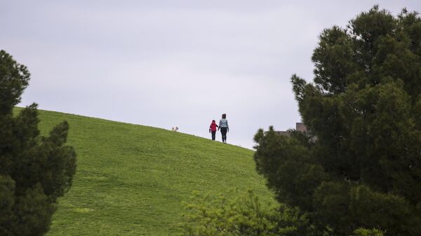 Женщина гуляет с ребенком в одном из парков Мадрида
