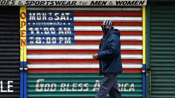 Мужчина в защитной маске у закрытого магазина в США