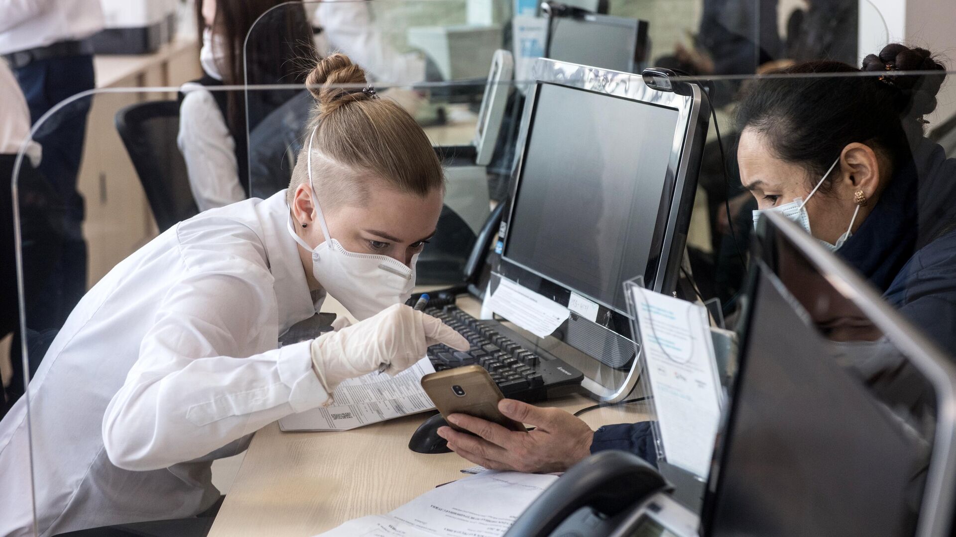 Сотрудница в защитной маске ведет прием посетителей в одном из отделений банка Открытие - РИА Новости, 1920, 15.01.2021